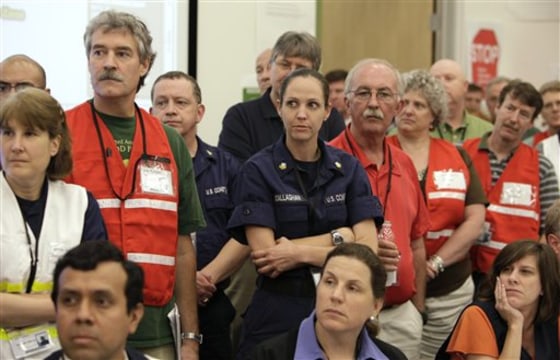 BP employees and members of the U.S. Coast Guard in the command center at the Houma Joint Information Center listen to BP Chief Operating Officer Doug Suttles speak about the Deepwater Horizon oil spill in Houma, La., in June.